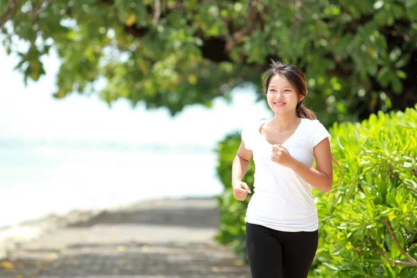 Flicka jogga på stranden — Stockfoto