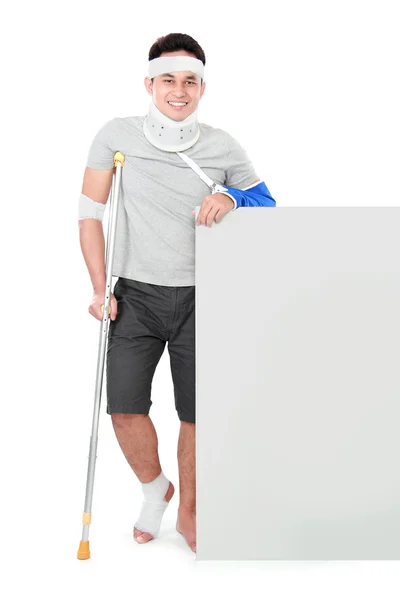 Male with broken arm and crutch presenting — Stock Photo, Image