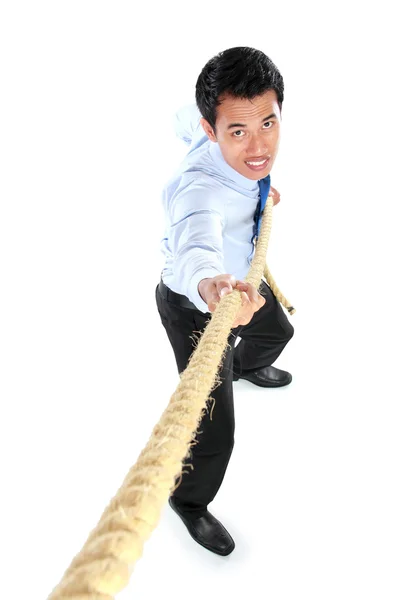 Νέος επιχειρηματίας τραβώντας ένα σχοινί, ενώ στέκεται — Φωτογραφία Αρχείου