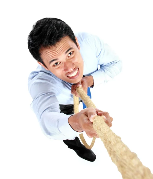 Young businessman climbing up by using a rope — Stock Photo, Image