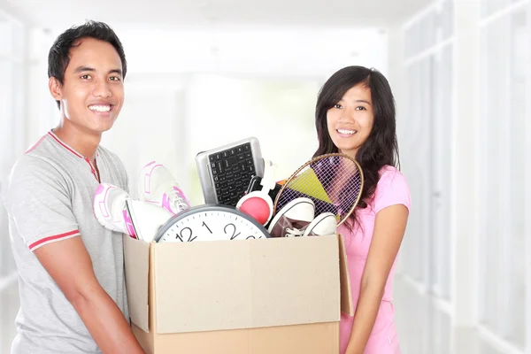 Moving day. couple with their stuff inside the cardboard box — Stock Photo, Image