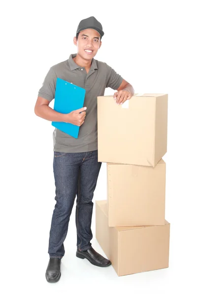 Sonriente joven repartidor con paquete de cartón — Foto de Stock