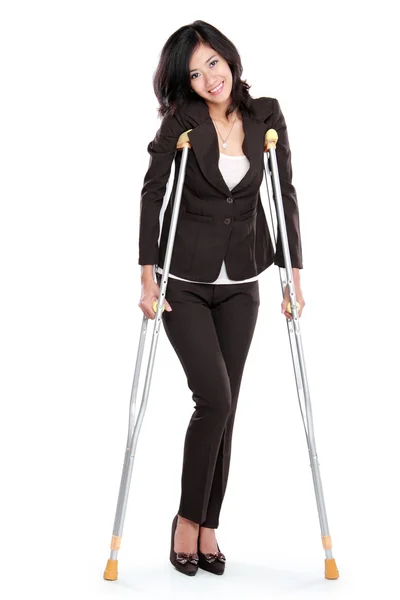 Business woman with crutches — Stock Photo, Image