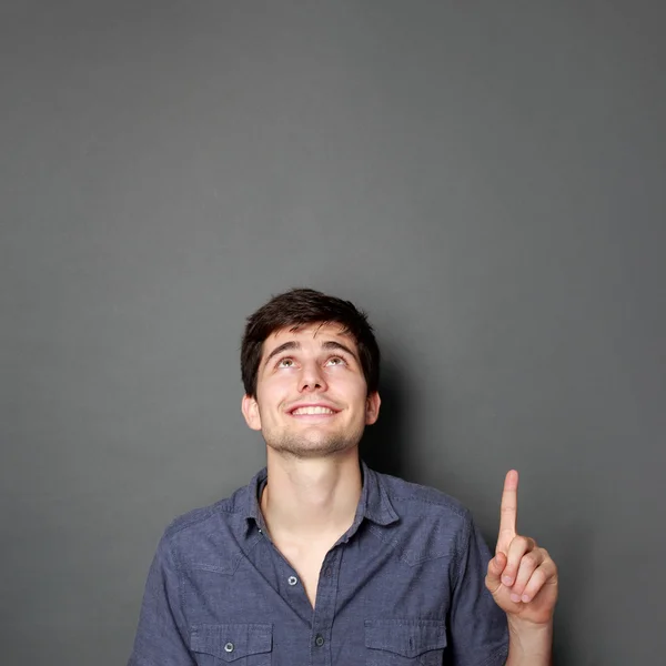 Man looking and pointing up to copy space — Stock Photo, Image