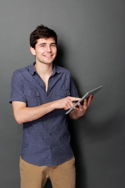 Fiatal férfi mosolyogva, digitális tábla használata — Stock Fotó