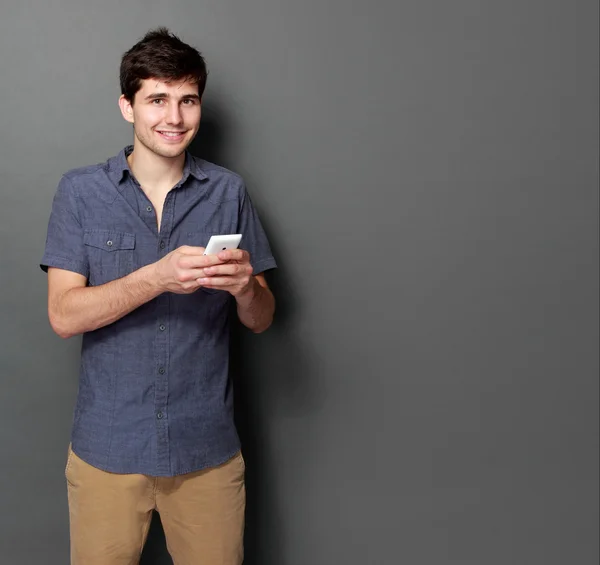 Jonge man lachend met behulp van mobiele telefoon — Stockfoto