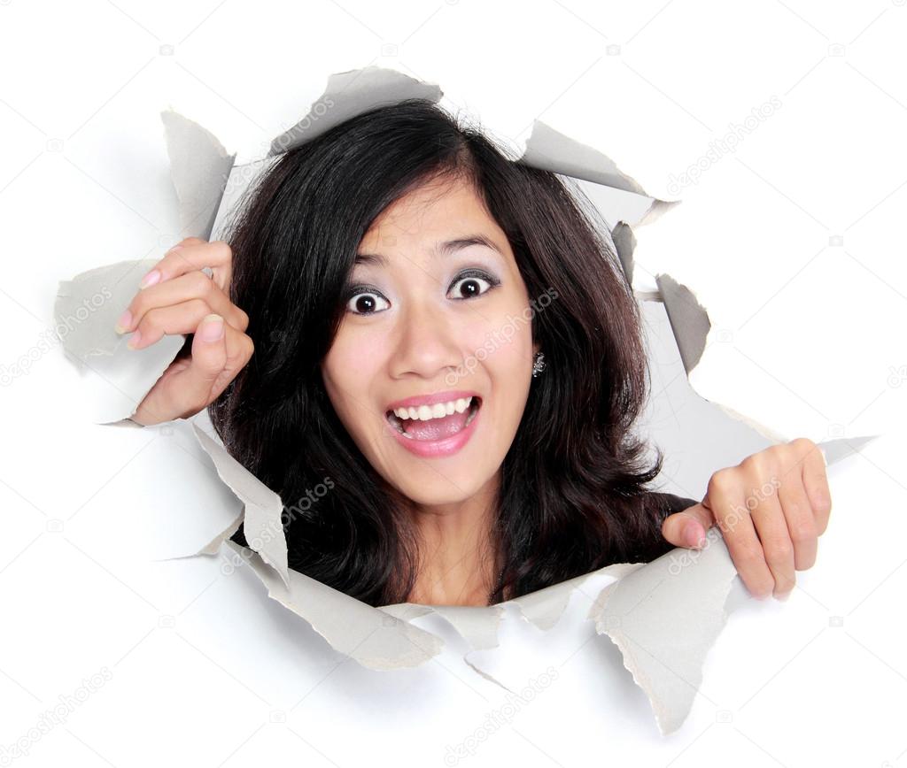 surprised young woman looking through a hole