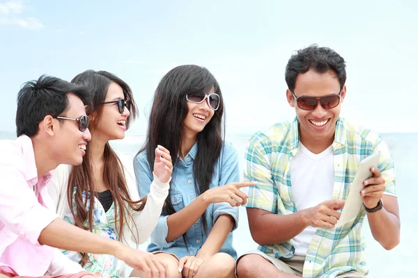 Groupe d'amis profiter de vacances à la plage avec tablette pc — Photo