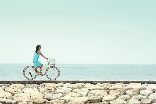 Woman having fun riding bicycle at the beach — Stok fotoğraf