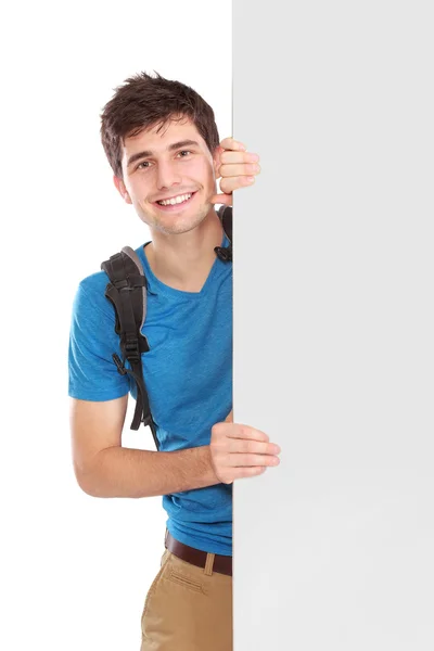 Jovem estudante masculino segurando placa branca em branco — Fotografia de Stock