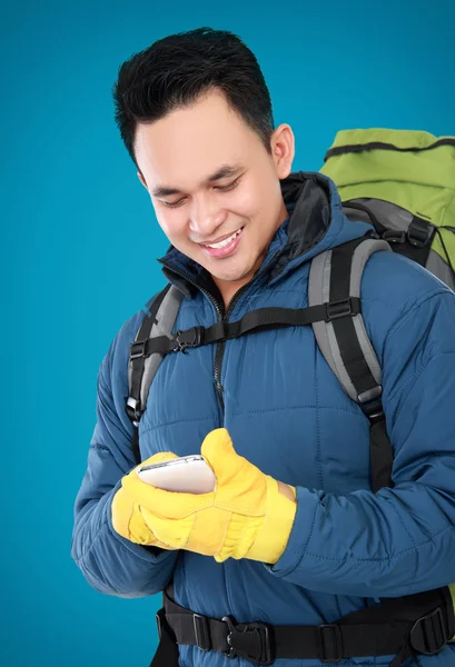 Male hiker with backpack using mobile phone — Stock Photo, Image