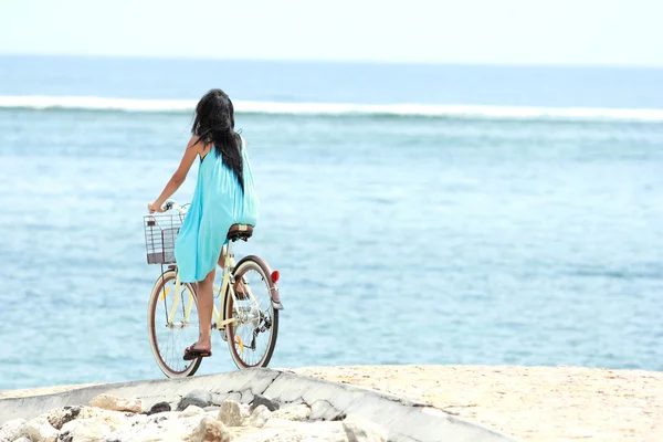Žena baví jedoucí na kole na pláži — Stock fotografie