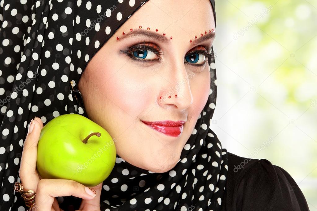 beautiful woman with black scarf holding green apple