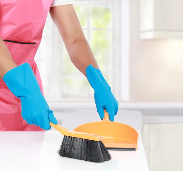 Hand with glove using cleaning broom to clean up — Stock Photo, Image