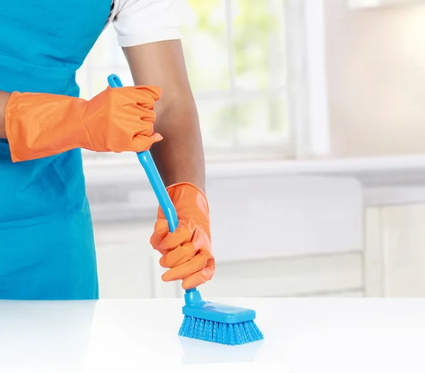 Mão com luva usando escova de limpeza para limpar — Fotografia de Stock