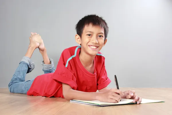 Jovem rapaz escrevendo no chão — Fotografia de Stock