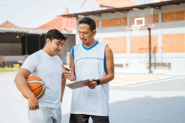 a basketball coach explains tactics and gives instructions to a player