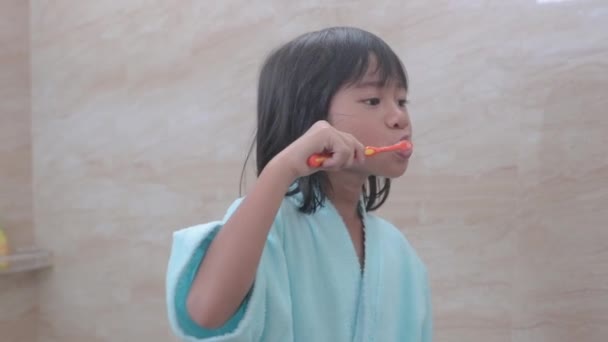 Gadis menggosok gigi di kamar mandi melihat cermin — Stok Video