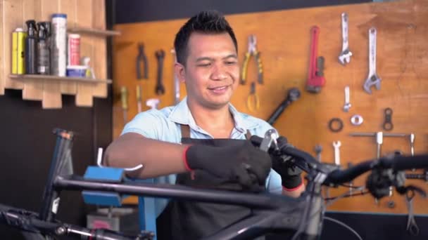 Egy kerékpárszerelő szerszámmal csavarja le a kormányrudakat. — Stock videók
