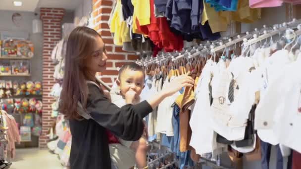 Indonesiska mor shopping kläder för sin son i baby butik — Stockvideo