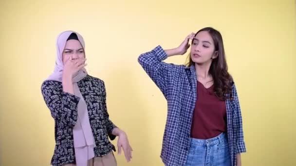 Woman lifts her armpits and a woman covers her nose because of the smell — Stock Video