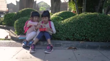 İlkokul öğrencisi beslenme çantasında yemek yemekten zevk alıyor.