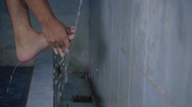 Müslüman adam ayaklarını yıkadı.