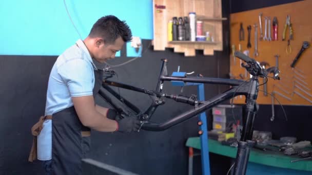 Een jonge reparateur in een schort als werkkleding met een tablet — Stockvideo