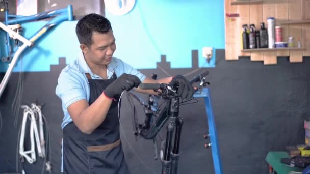 Młody mechanik w fartuchu jako ubranie robocze za pomocą tabletu — Wideo stockowe