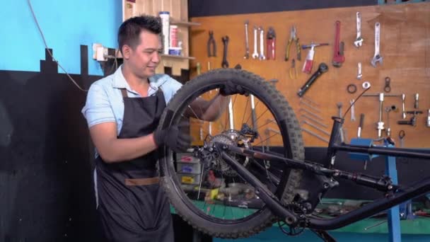 Mécanicien de vélo dans les tabliers d'installation des roues tout en fixant les problèmes — Video