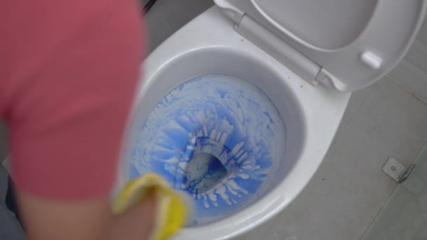 Κλείσιμο των χεριών φορώντας γάντια χρησιμοποιώντας βούρτσα κατά τον καθαρισμό της τουαλέτας — Αρχείο Βίντεο
