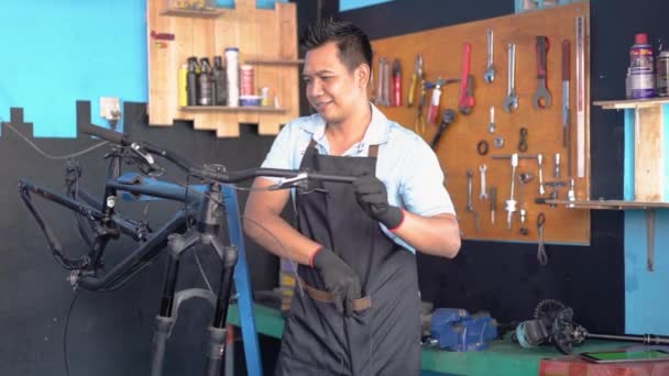 Młody mechanik w fartuchu jako ubranie robocze za pomocą tabletu — Wideo stockowe