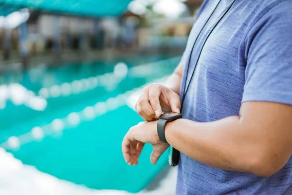 Primer plano de una mano de cochecitos de natación sosteniendo un reloj — Foto de Stock