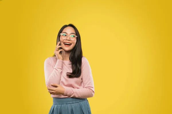 Schöne asiatische Frau mit Brille lächelt beim Telefonieren mit einem Handy — Stockfoto