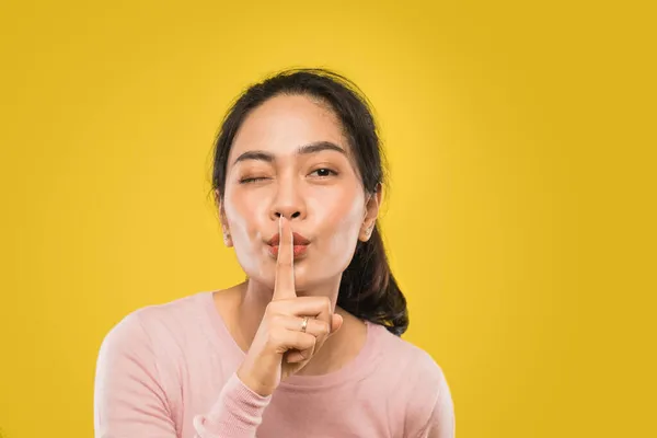 Asijská žena s jedním okem zavřeným a gestem ruky tiché prosím — Stock fotografie