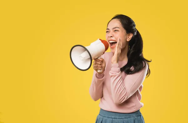 Asian woman screaming while holding megaphone with two hands making announcement — Stock Photo, Image