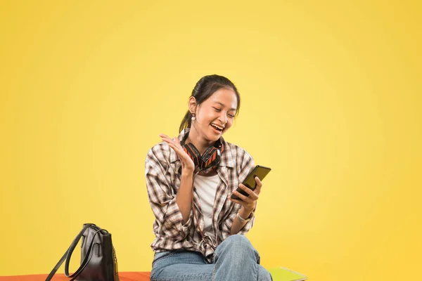 Gelukkig meisje het lezen van bericht tijdens het kijken naar telefoon scherm tijdens het zitten — Stockfoto