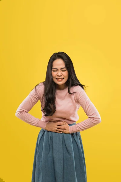 Mulher asiática com braços no estômago e curvando-se com expressão de dor menstrual — Fotografia de Stock