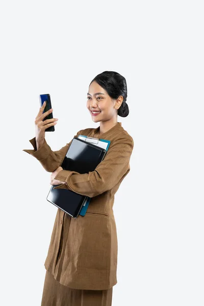 Profesora de uniforme hace una llamada usando el teléfono mientras lleva el portátil — Foto de Stock