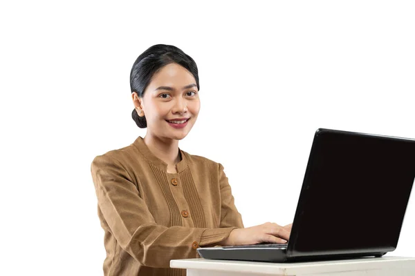 Mulher sorridente em uniforme de funcionário público usando laptop para trabalhar — Fotografia de Stock