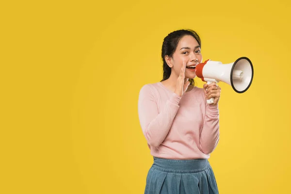 Chica con las manos al lado de la boca haciendo anuncio usando megáfono — Foto de Stock