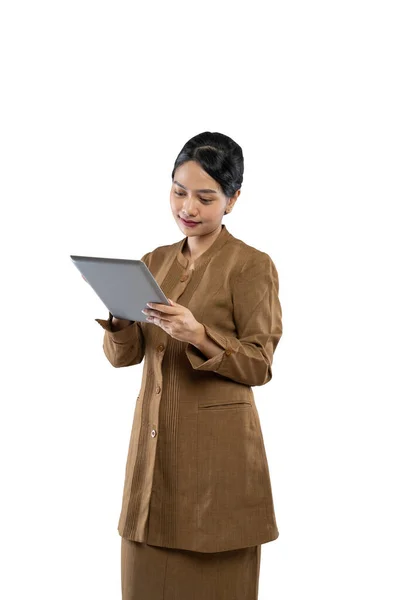 Mujer joven con uniforme caqui de pie usando una tableta digital —  Fotos de Stock