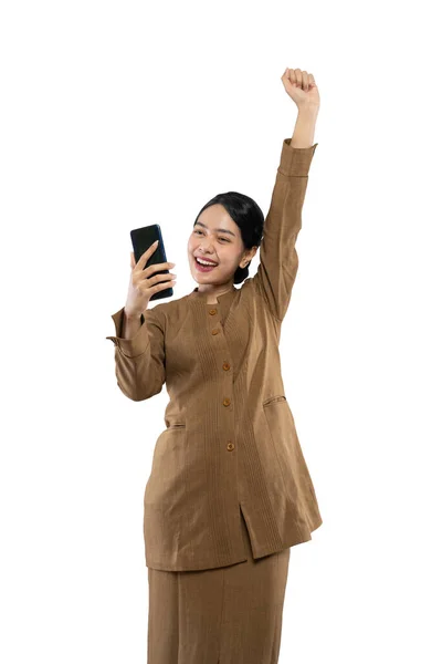 Γυναίκα με στολή ενθουσιασμένη κοιτάζοντας το χέρι του τηλεφώνου της ψηλά — Φωτογραφία Αρχείου