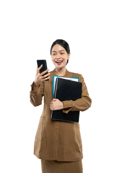 Nauczycielka w mundurze dzwoni przez telefon podczas noszenia laptopa — Zdjęcie stockowe