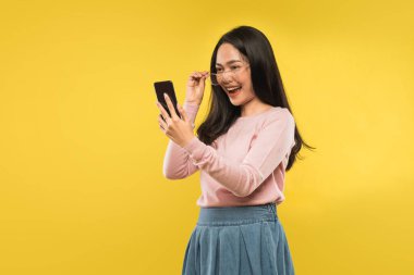 Güzel bir kadın akıllı telefonun ekranına bakıp gülüyor.