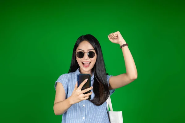 Excited asian woman while using a mobile phone — Stock Photo, Image