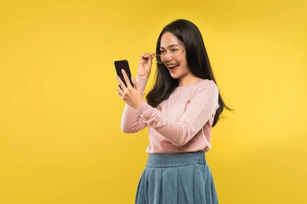Vacker kvinna skrattar tittar på skärmen på en smartphone — Stockfoto
