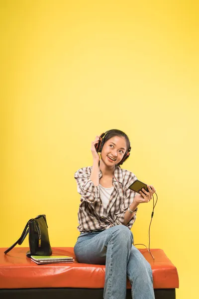 Auriculares de niña jugando juego con un teléfono móvil —  Fotos de Stock