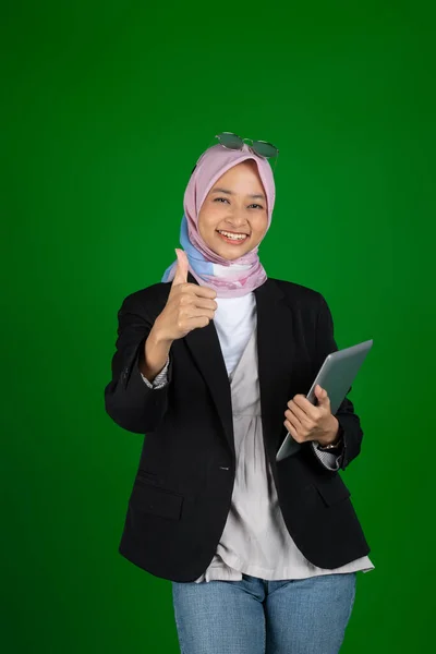 Мусульманская девушка в хиджабе с цифровым планшетом с большим пальцем вверх — стоковое фото