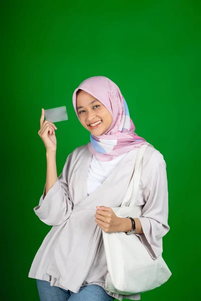 Asiático chica en hijab sonriendo mientras celebración atm tarjeta —  Fotos de Stock